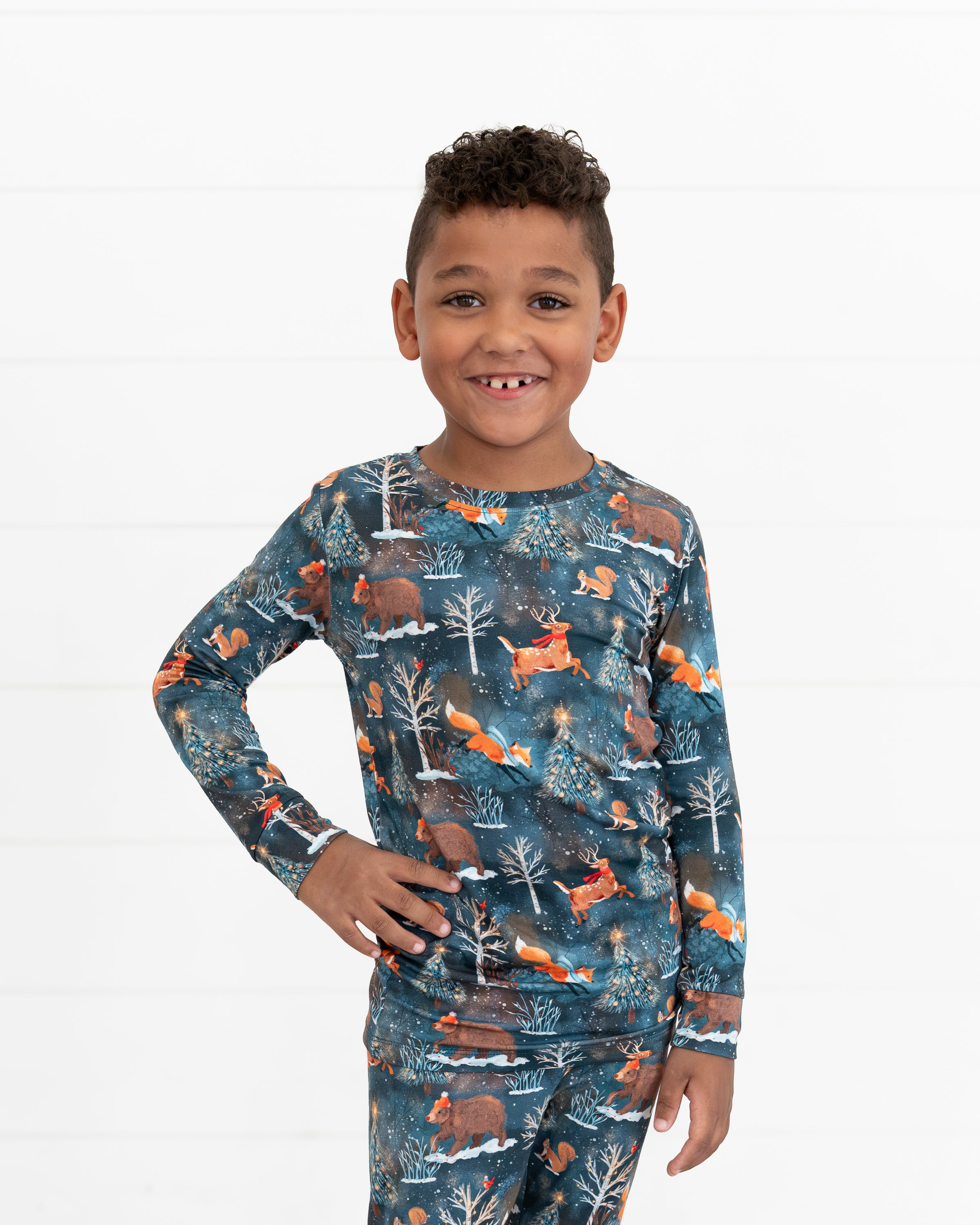 Young boy standing with hands on hips wearing Woodland Wonder bamboo kids two-piece pajamas