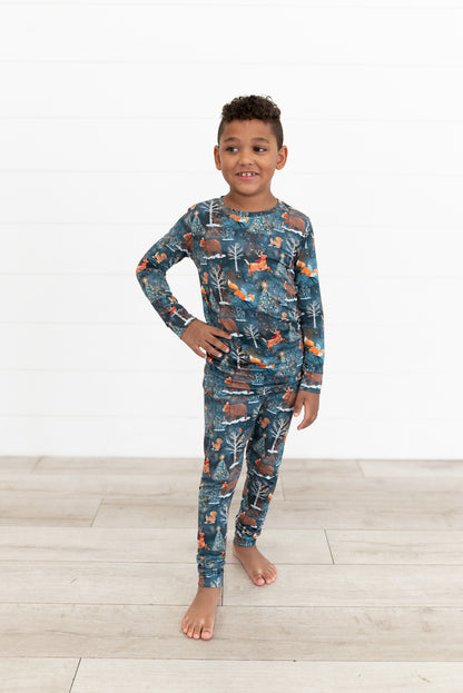 Young boy standing with hand on hip wearing Woodland Wonder bamboo kids two-piece pajamas