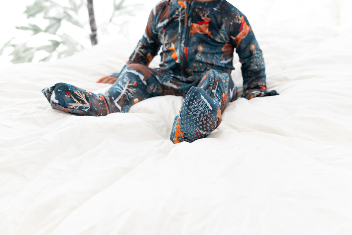 Close-up of Woodland Wonder bamboo baby zip pajamas showing footed detail and white piping