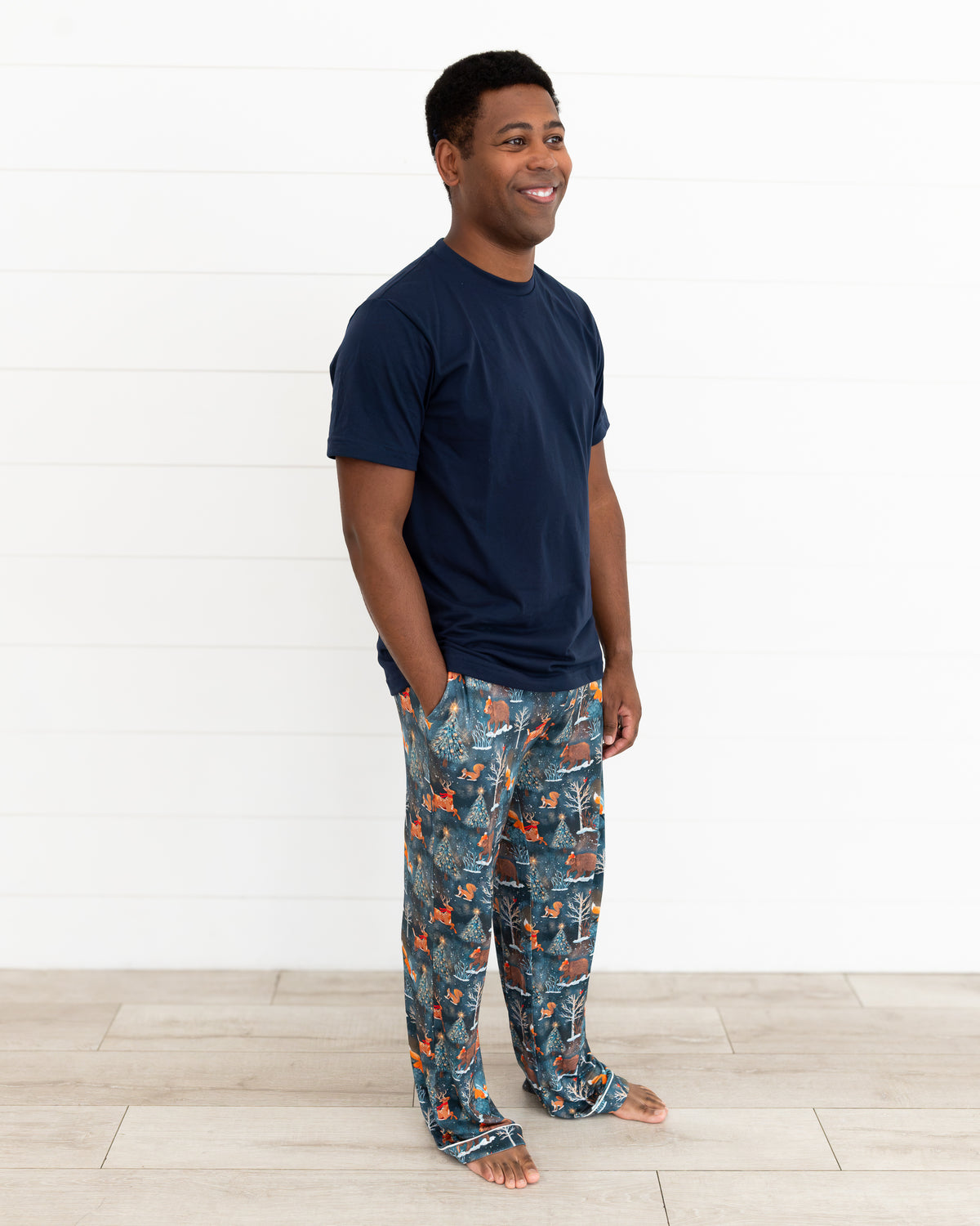 Man standing in Woodland Wonder bamboo men's pajama pants with a navy t-shirt