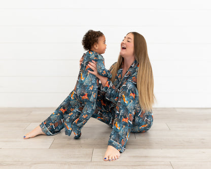 Mom sitting on the floor laughing with a toddler, both in matching Woodland Wonder bamboo pajamas