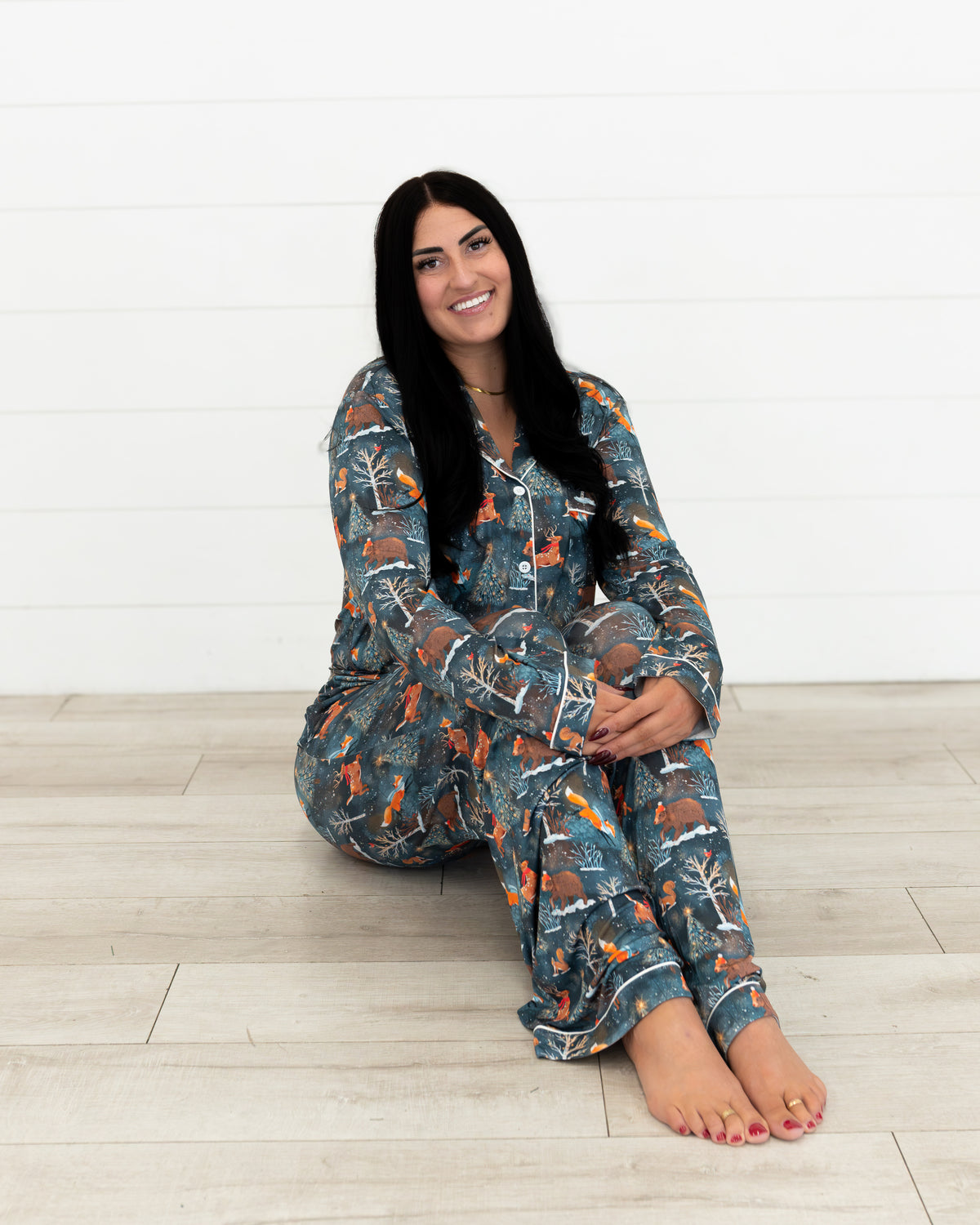Woman sitting on the floor with legs crossed wearing Woodland Wonder bamboo women's pajama pants