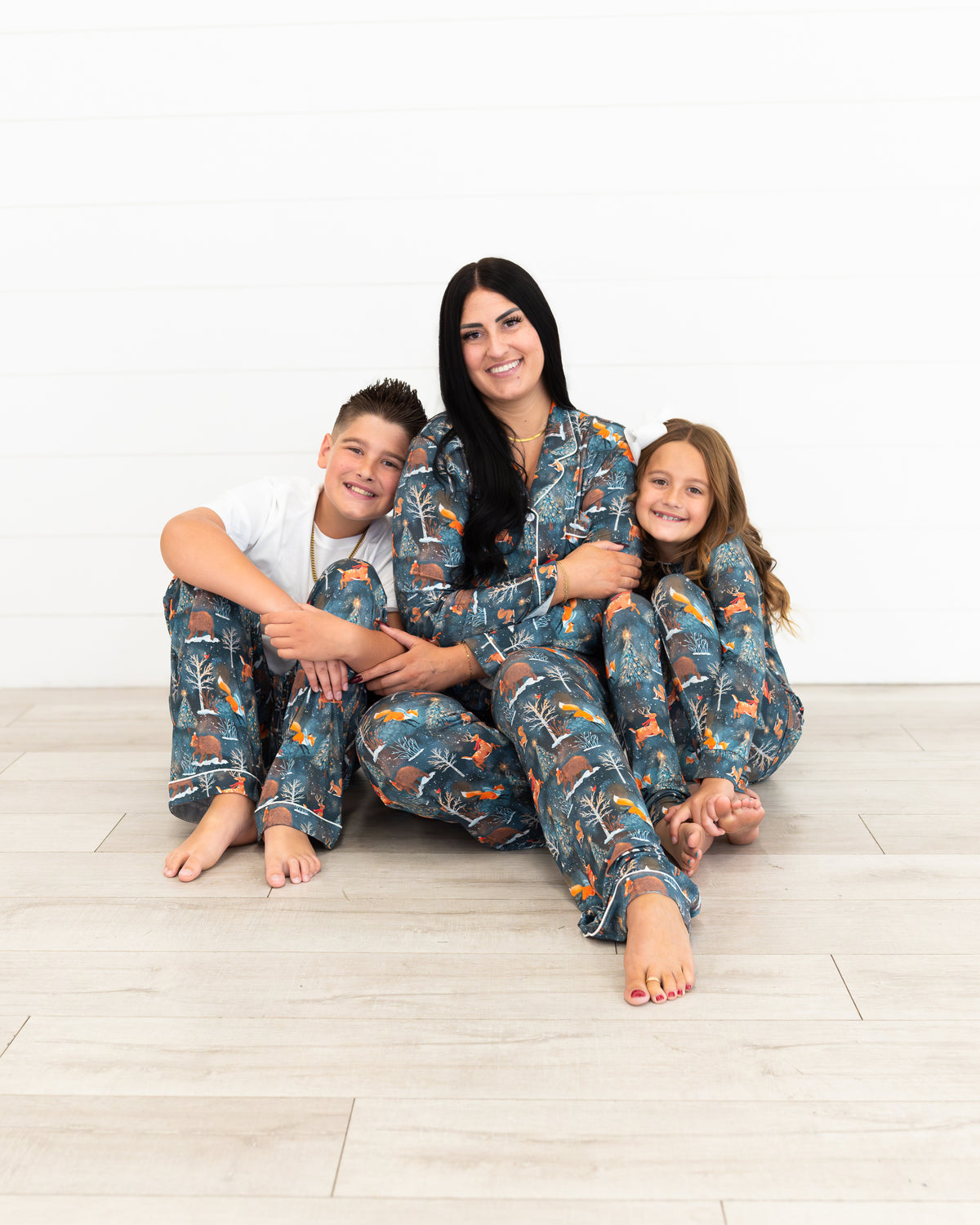 Mom with two kids wearing matching Woodland Wonder bamboo Christmas pajamas