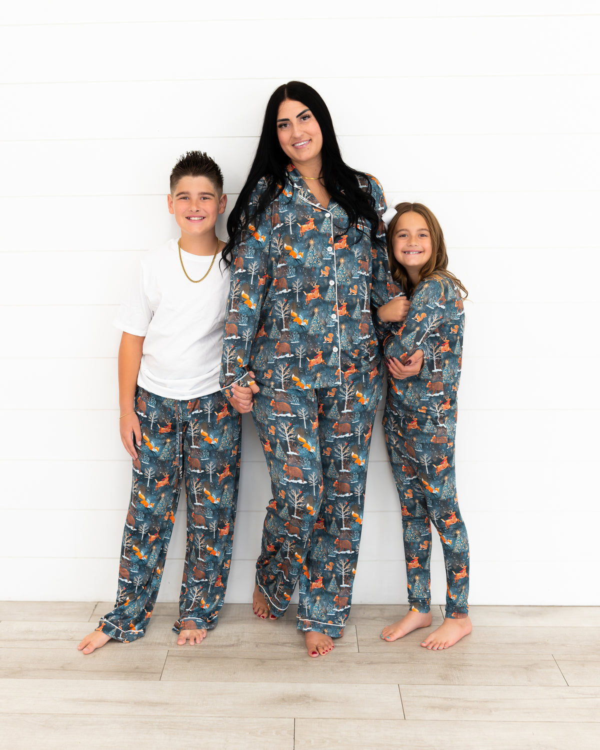 Woman with a boy and teen girl standing together in matching Woodland Wonder bamboo pajamas