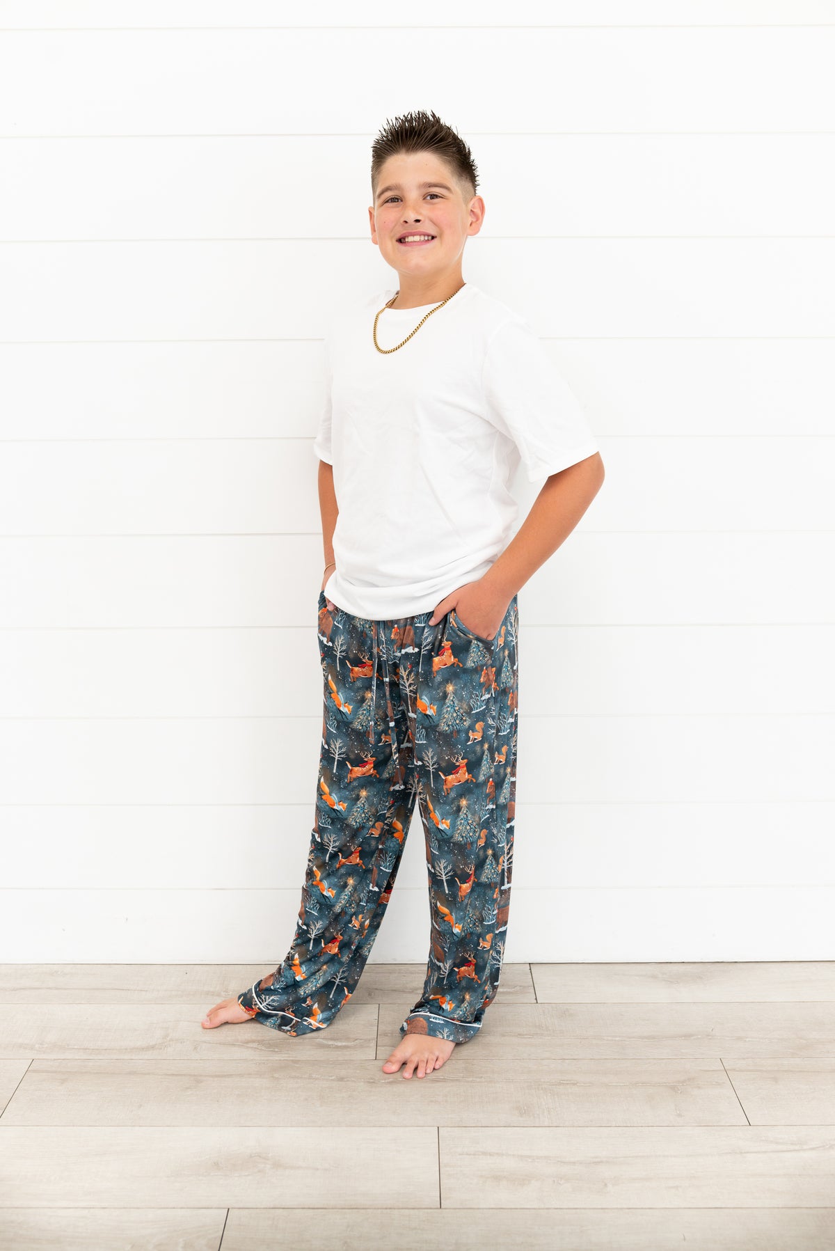 Boy standing with hand in pocket wearing a white t-shirt and Woodland Wonder bamboo pajama pants