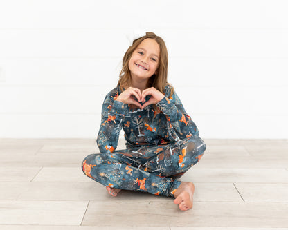 Teen girl making a heart with her hands wearing Woodland Wonder bamboo teen pajamas