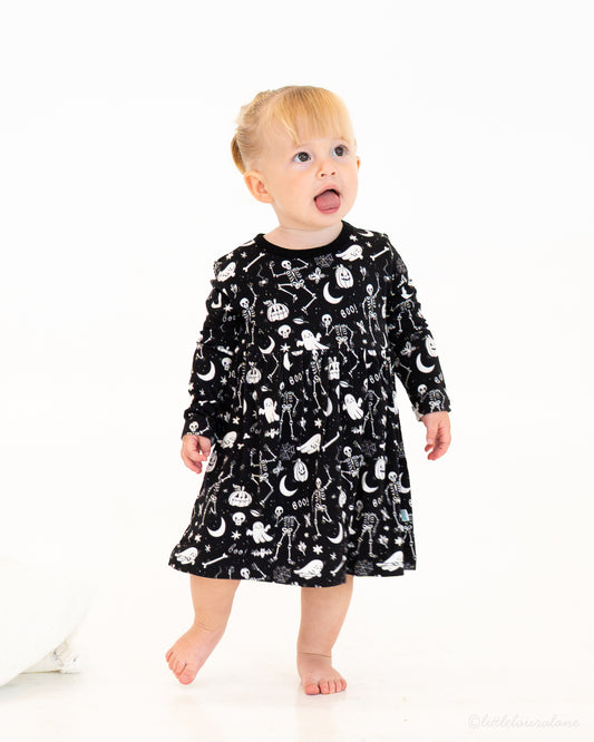 Skeleton Party Black & White Halloween Bamboo Baby Dress – on-model, toddler in black skeleton-print baby dress