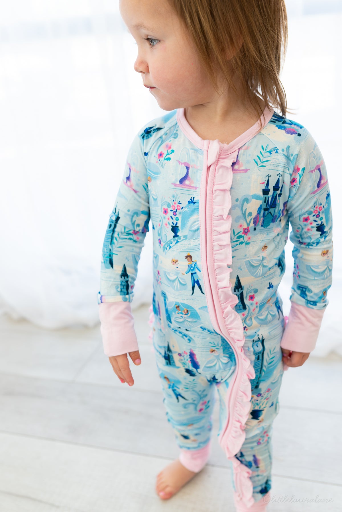 Baby Princess Pajama – The Wish Collection – on-model front view, toddler in blue castle-print zip pajama