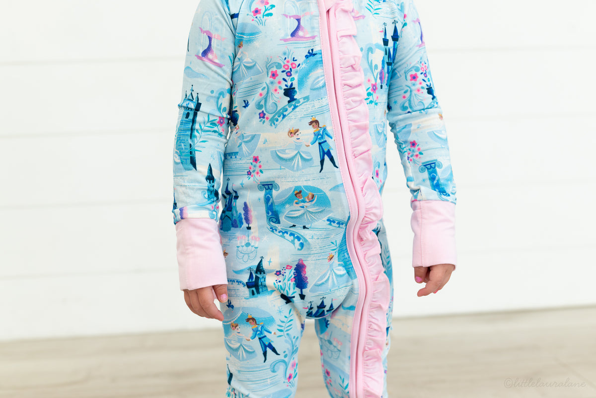 Baby Princess Pajama – The Wish Collection – on-model close-up of blue castle-print zip pajama with pink ruffled zipper