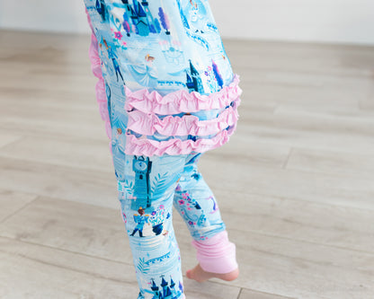 Baby Princess Pajama – The Wish Collection – on-model close-up of blue castle-print zip pajama pants with pink ruffles