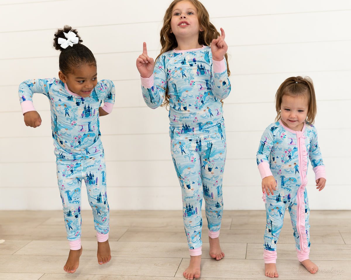 Two Piece Princess Pajama – The Wish Collection – on-model, three girls dancing in matching blue castle-print pajamas
