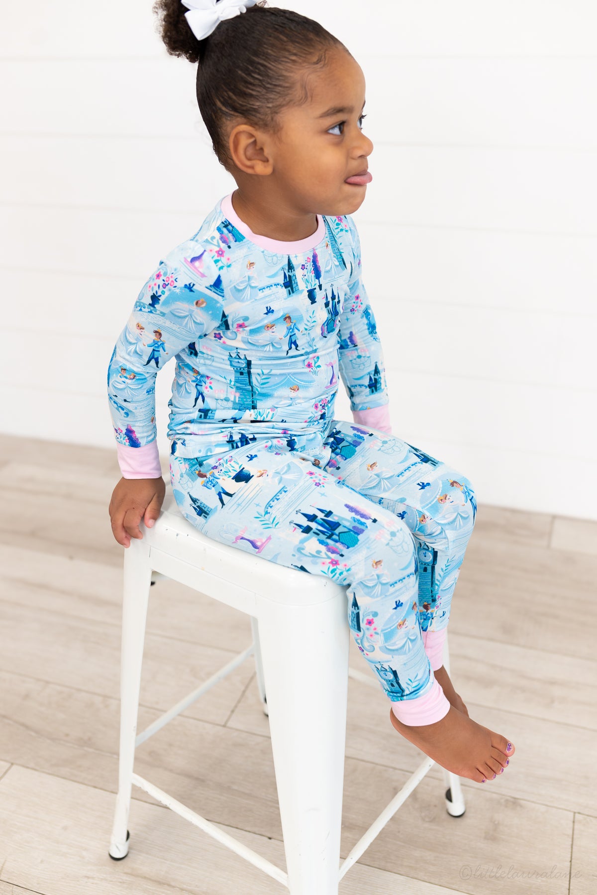 Two Piece Princess Pajama – The Wish Collection – on-model, child sitting on stool in blue castle-print pajamas