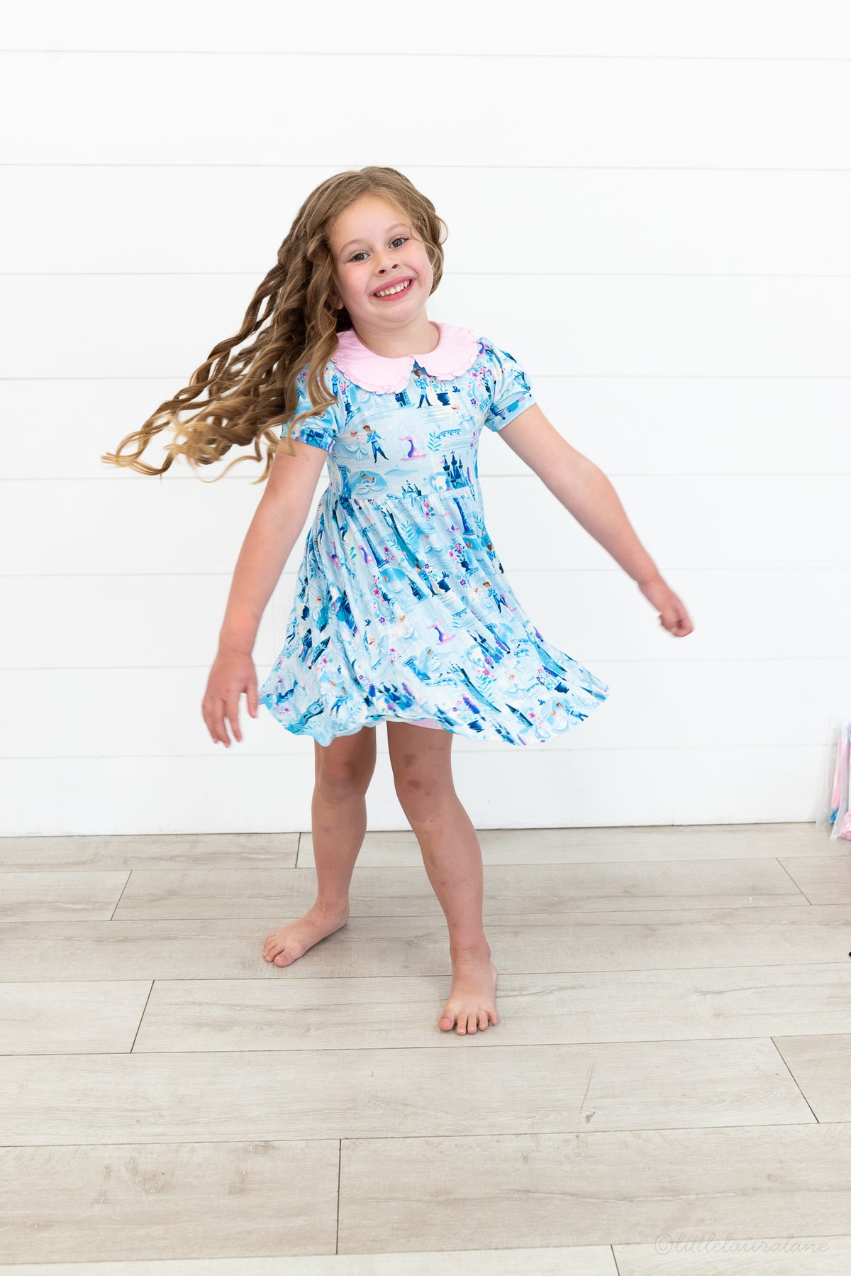Girls Princess Dress with Shorts – The Wish Collection – on-model lifestyle, girl twirling in blue castle-print dress