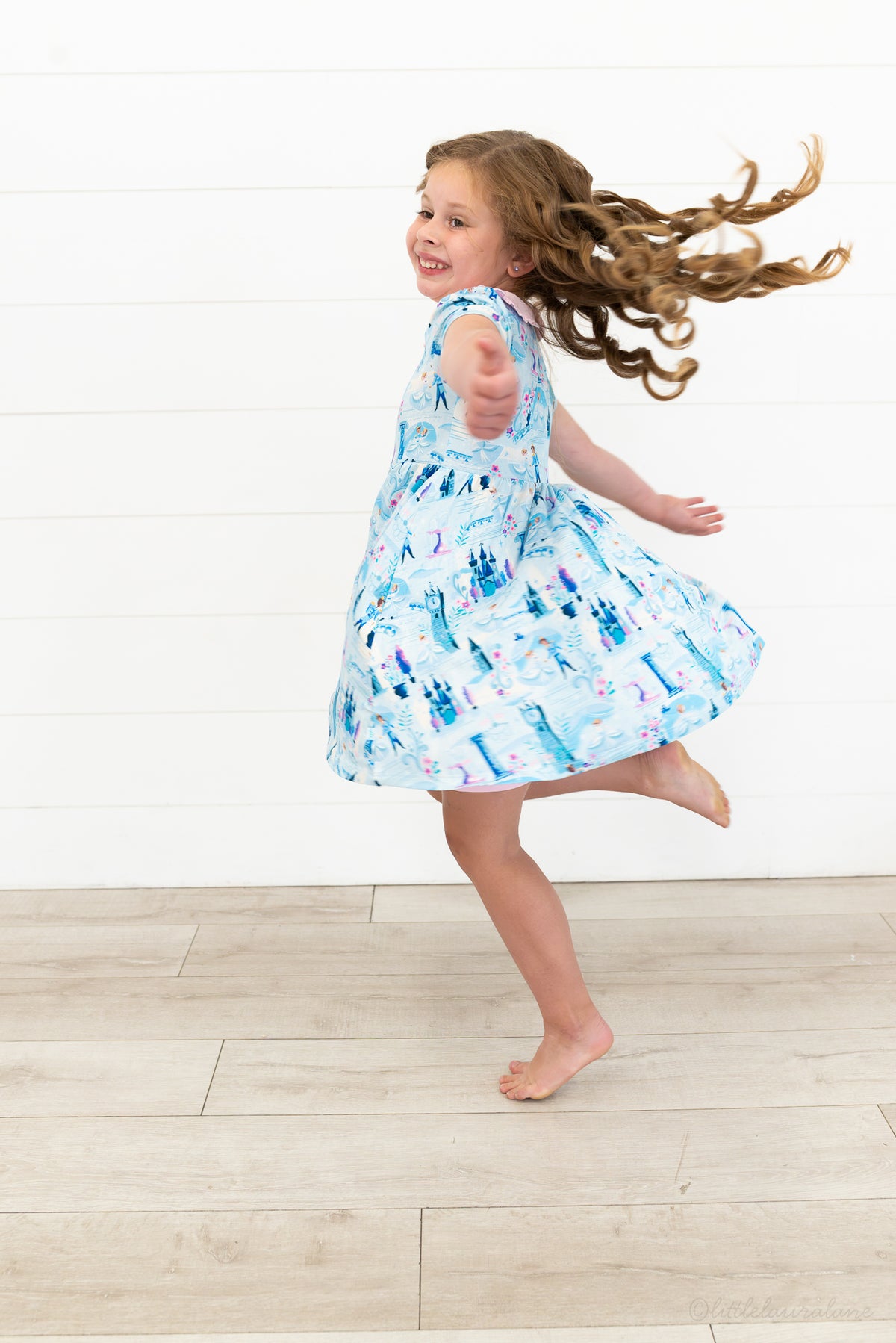 Girls Princess Dress with Shorts – The Wish Collection – on-model lifestyle, girl mid-spin in blue castle-print dress