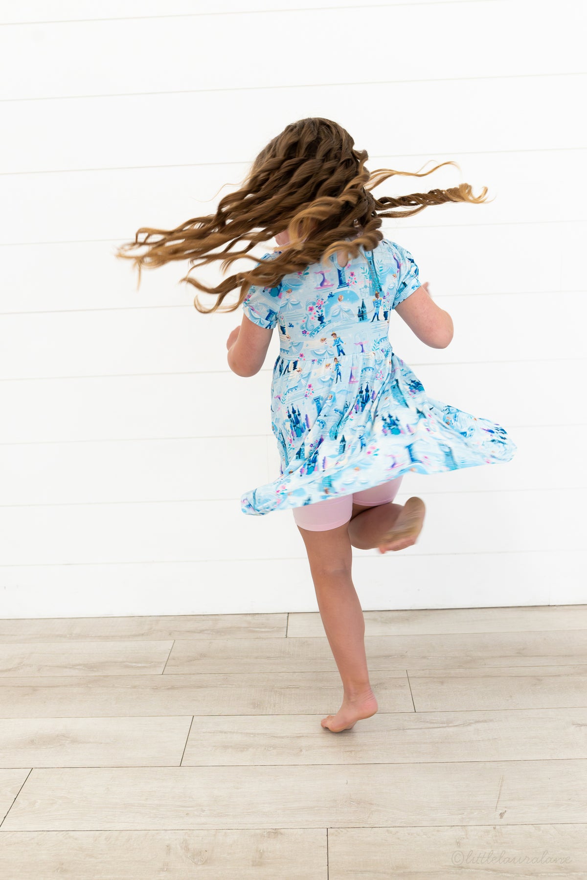 Girls Princess Dress with Shorts – The Wish Collection – on-model back view, twirling in blue castle-print dress