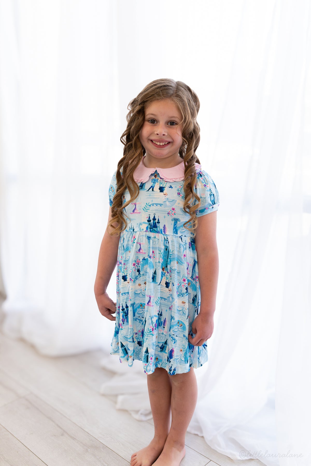 Girls Princess Dress with Shorts – The Wish Collection – on-model front view, girl in blue castle-print dress, bright room