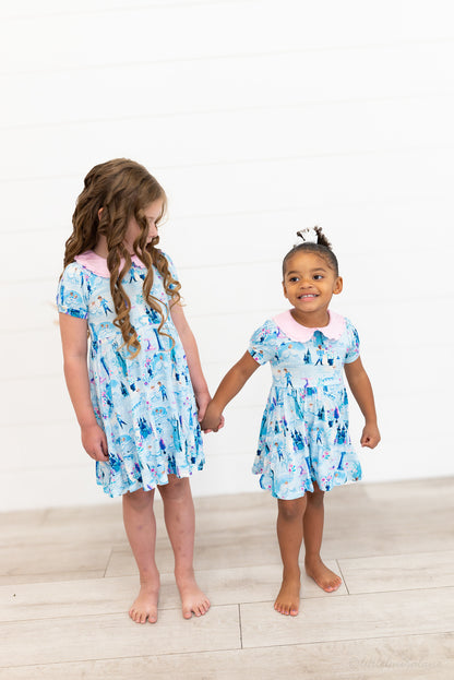 Girls Princess Dress with Shorts – The Wish Collection – two girls holding hands in matching blue castle-print dresses