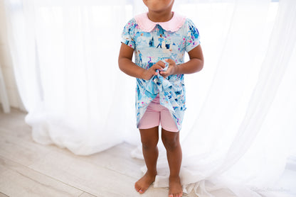 Girls Princess Dress with Shorts – The Wish Collection – on-model front view, blue castle-print dress and pink shorts