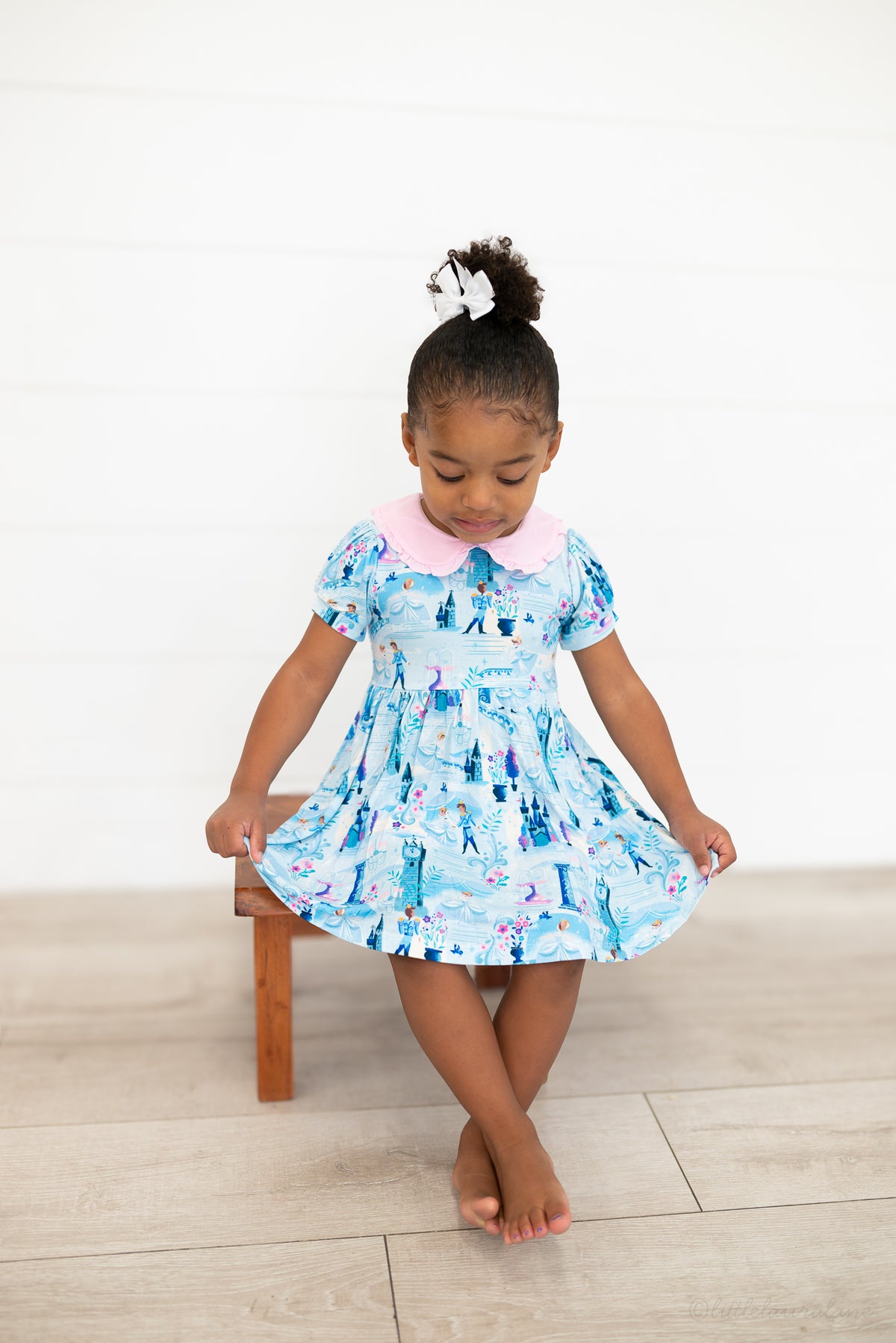 Girls Princess Dress with Shorts – The Wish Collection – on-model front view, girl on stool in blue castle-print dress