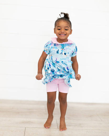Girls Princess Dress with Shorts – The Wish Collection – on-model front view, blue castle-print dress with pink shorts